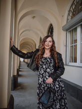 A lady wears a leather jacket and a maxi dress.